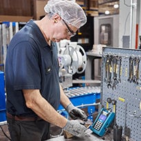 Worker using a machine in the Mother Parkers' factory