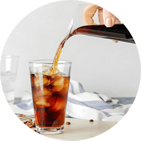 Cold brew coffee pouring into a tall glass with ice