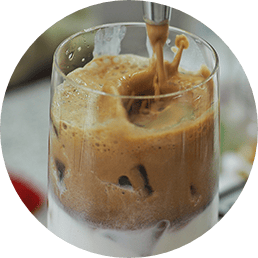 Coffee pouring into a cup of ice and cream from a brewing machine